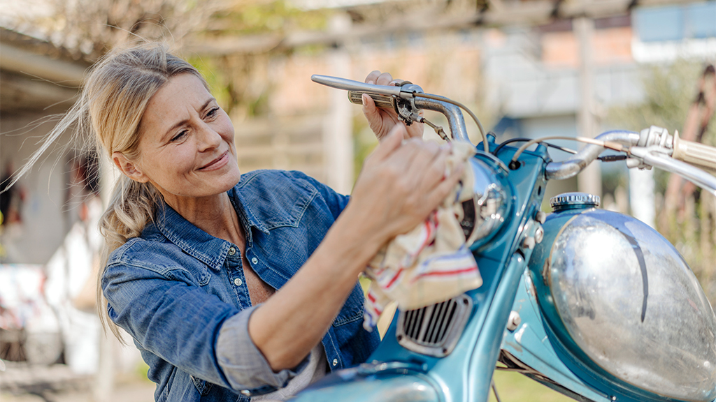 Frau schraubt an Motorrad