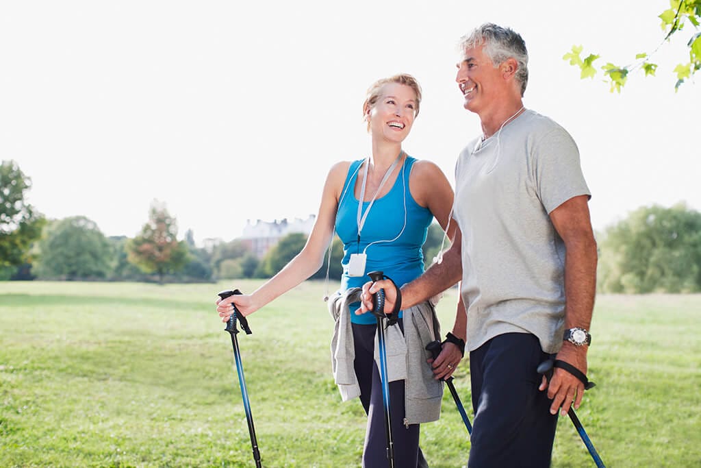 Ein älteres Paar beim Nordic Walking.