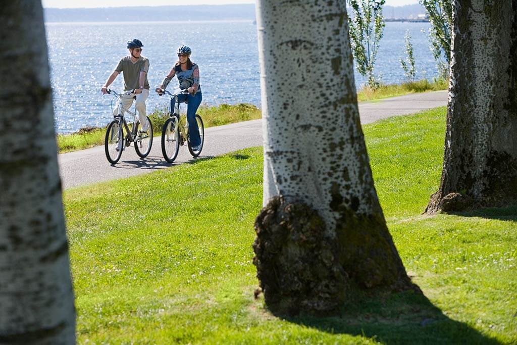 Ein Paar fährt Fahrrad am See.