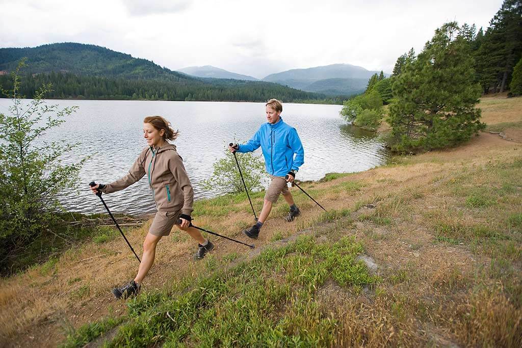 Ein Paar macht Nordic Walking an einem See.