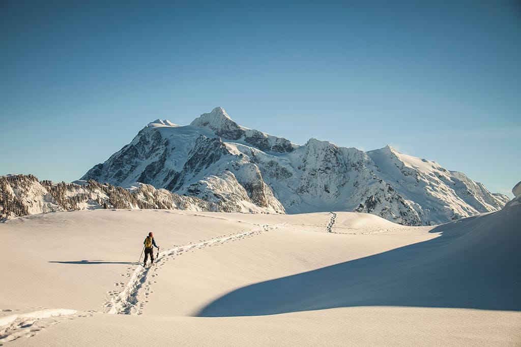 Eine einzelne Person wandert allein durch eine Schneelandschaft.