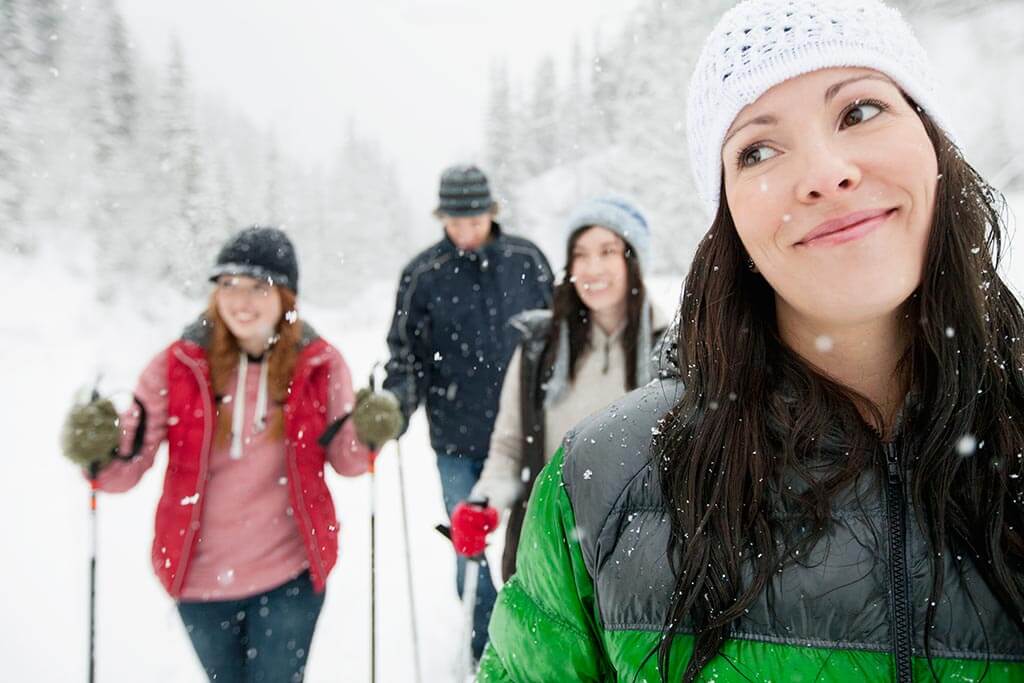 Eine Gruppe junger Menschen die durch den Schnee wandern.