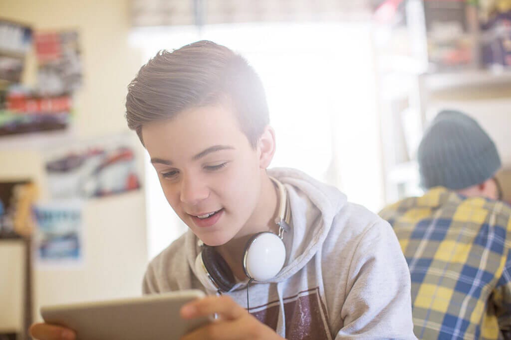 Junge schaut auf sein Tablet.