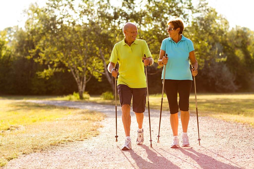 Ein älteres Paar macht zusammen Nordicwalking.