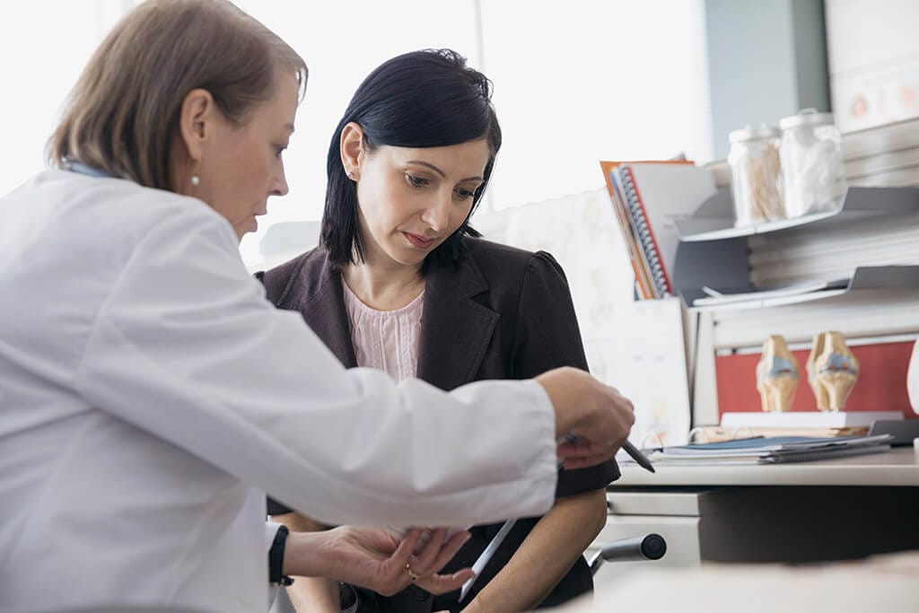 Ärztin erklärt einer Patientin etwas.