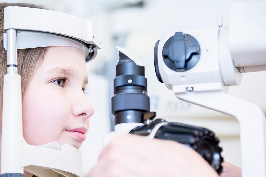 Ein junges Mädchen wird beim Augenarzt untersucht.