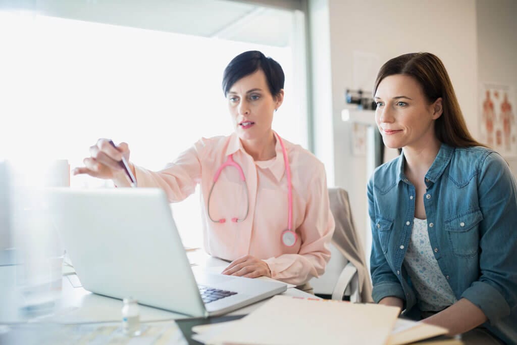 Ärztin informiert Patientin am PC