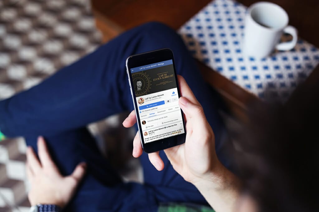 Mann im Cafe browst durch sein Handy