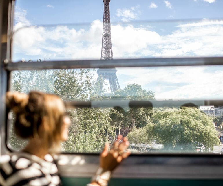 Frau in Bahn blickt auf Eifelturm