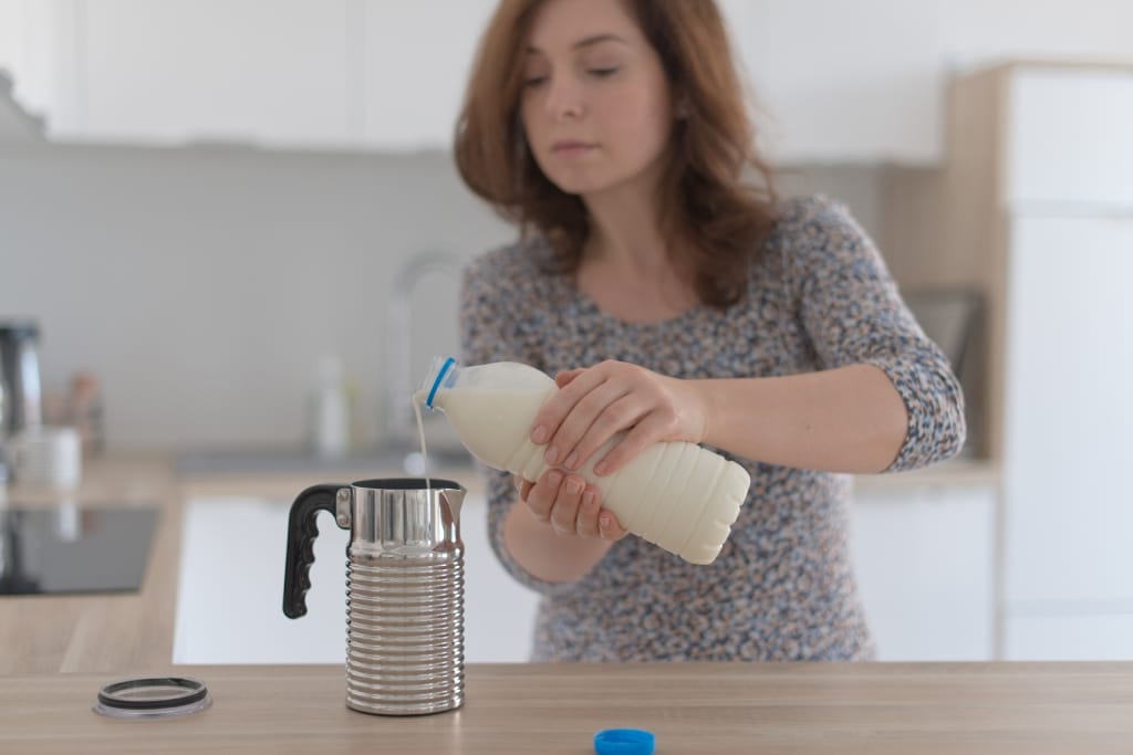 Eine Frau füllt Milch mit zwei Händen um