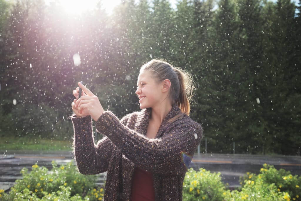 Frau macht ein Bild im Regen