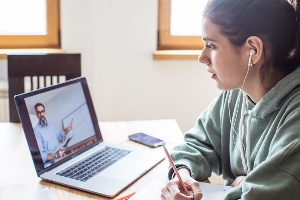 Frau vor dem Laptop notiert sich etwas