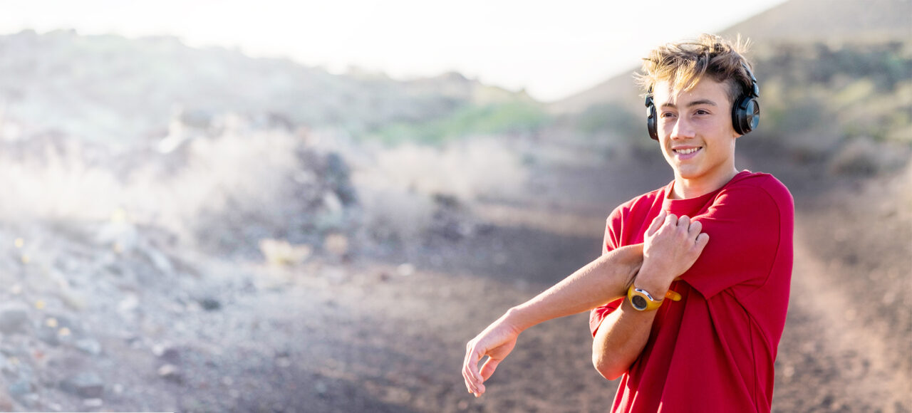 Ein Teenager mit Neurodermitis hat Kopfhörer an und macht sich zum Joggen bereit
