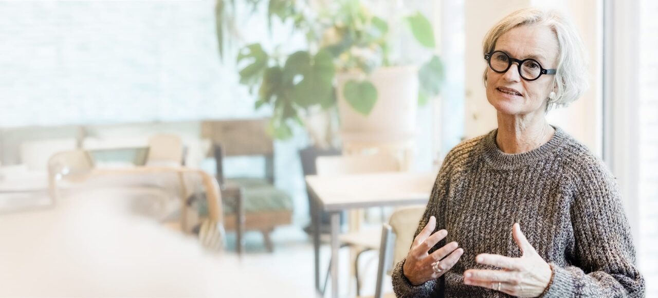 Ältere Frau mit kurzen grauen Haaren ist in einer Unterhaltung