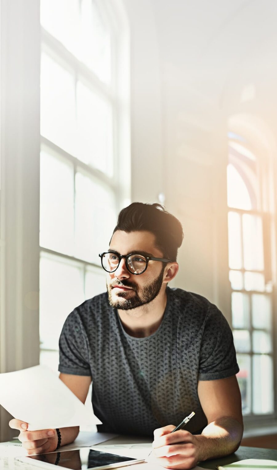 Mann mit schwarzen Haare und Brille schreibt etwas auf