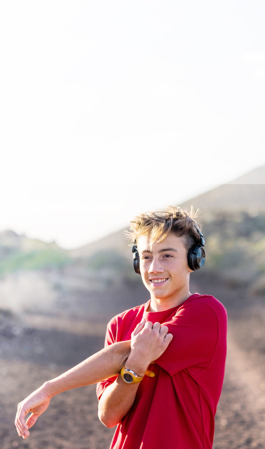 Ein Teenager mit Neurodermitis hat Kopfhörer an und macht sich zum Joggen bereit