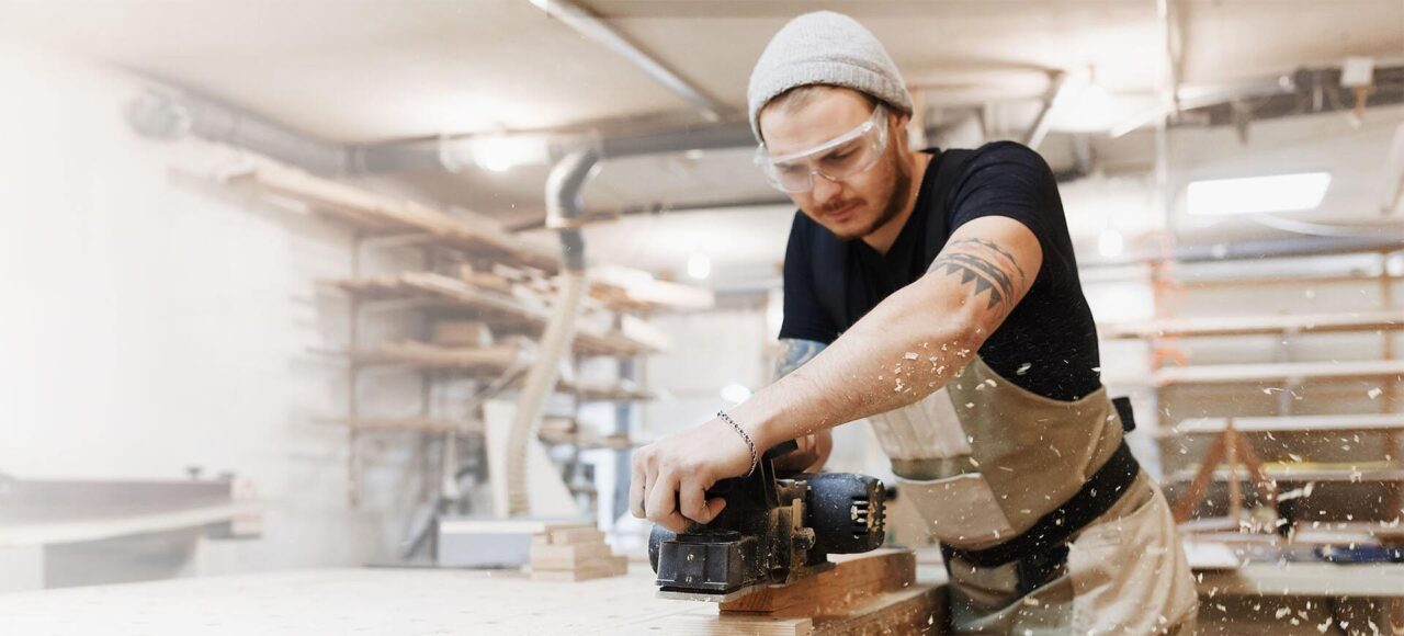 Junger Mann beim Arbeiten in einer Holzwerkstatt.