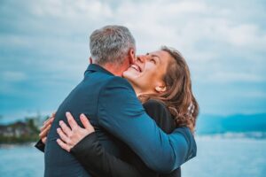 Mann und Frau umarmen sich, ein See ist im Hintergrund