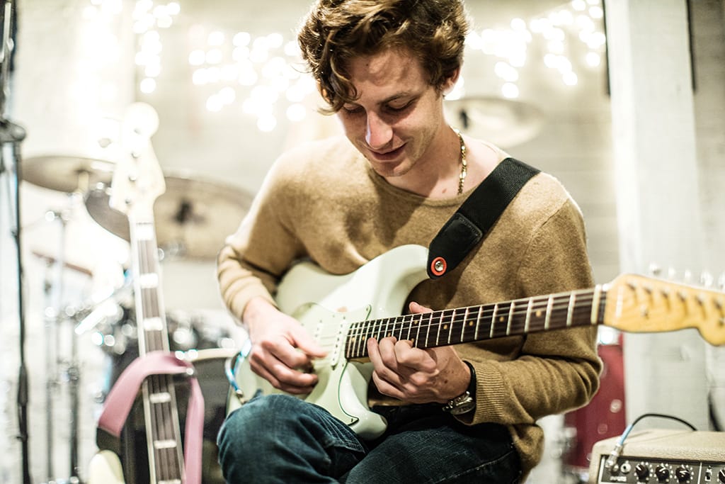 Junger Mann mit Neurodermitis spielt E-Gitarre