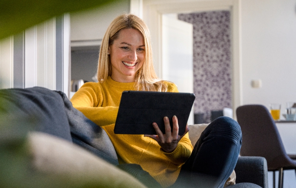 Frau auf Sofa bedient ihr Tablet