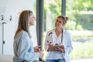 Frau mittleren Alters im Gespräch mit einer jungen Ärztin