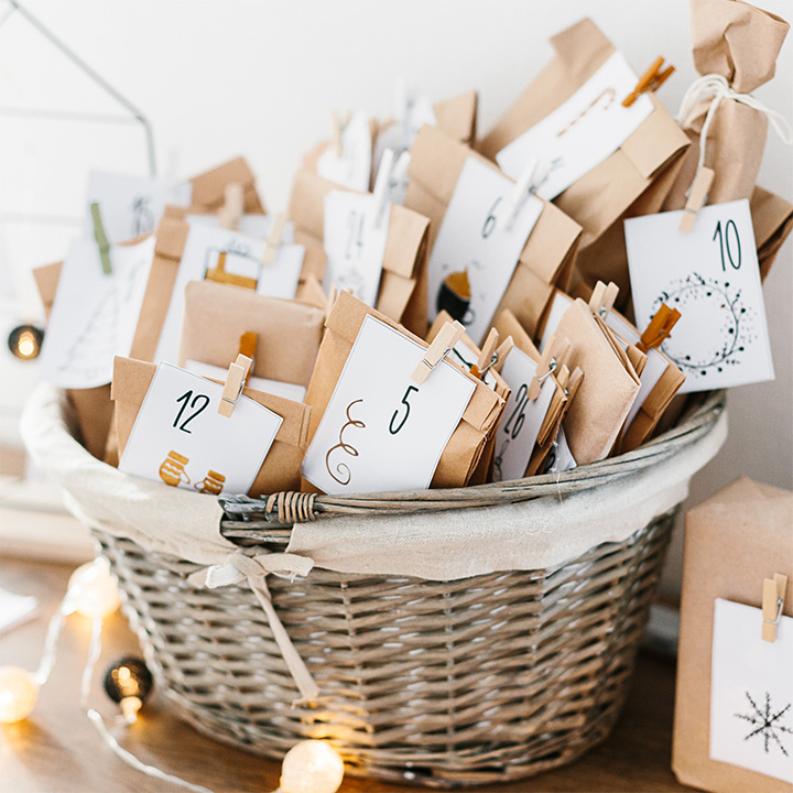 Adventskalender wartet auf Weihnachten. Korb mit Umschlägen mit Nummern und Aufgaben für Kinder, die auf einem Schrank stehen