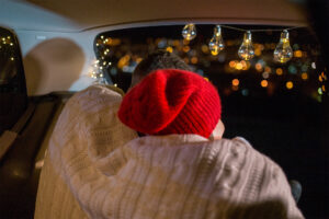 Frau mit roter Mütze schaut auf ein weihnatlich geschmücktes Feld