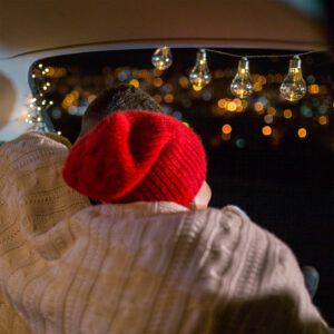 Frau mit roter Mütze schaut auf ein weihnatlich geschmücktes Feld