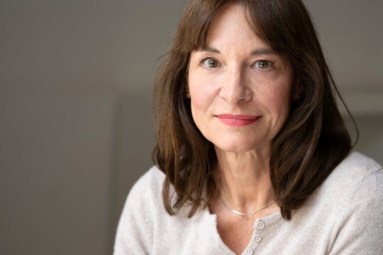  Frau Anfang 50 sitzt auf einem Stuhl