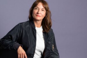 Frau Anfang 50 sitzt auf einem Stuhl