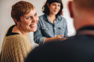 Frau mit kurzen Haaren nimmt bei einer Selbsthilfegruppe teil